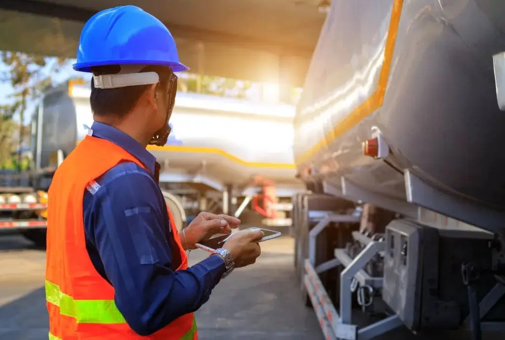 Fuel delivery driver checking a tanker before a commercial delivery