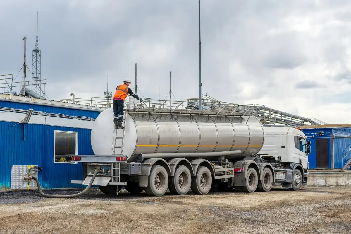 Fuel tanker delivering to a storage tank at a manufacturing site