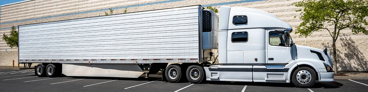 Refrigerated trailer with its reefer unit coupled to a white semi tractor