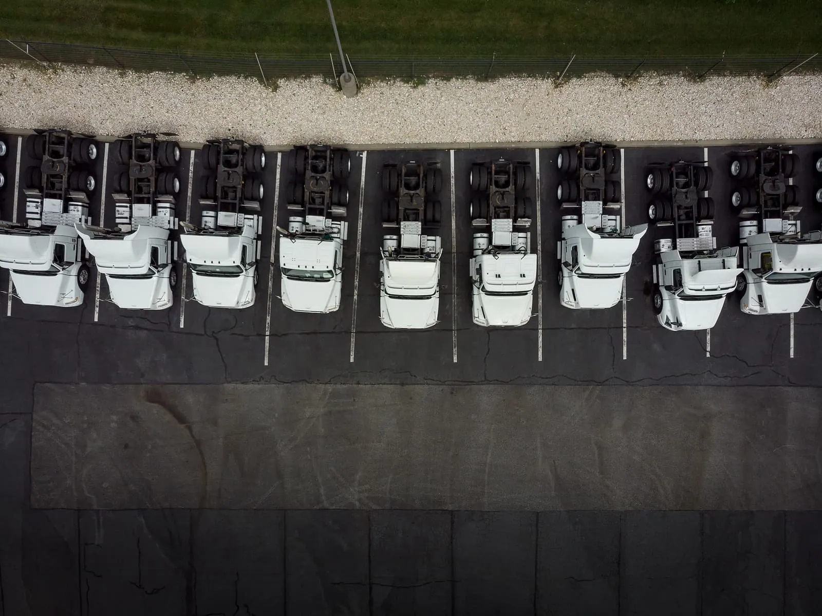 Aerial view of semi-truck tractors parked in a row at a logistics yard