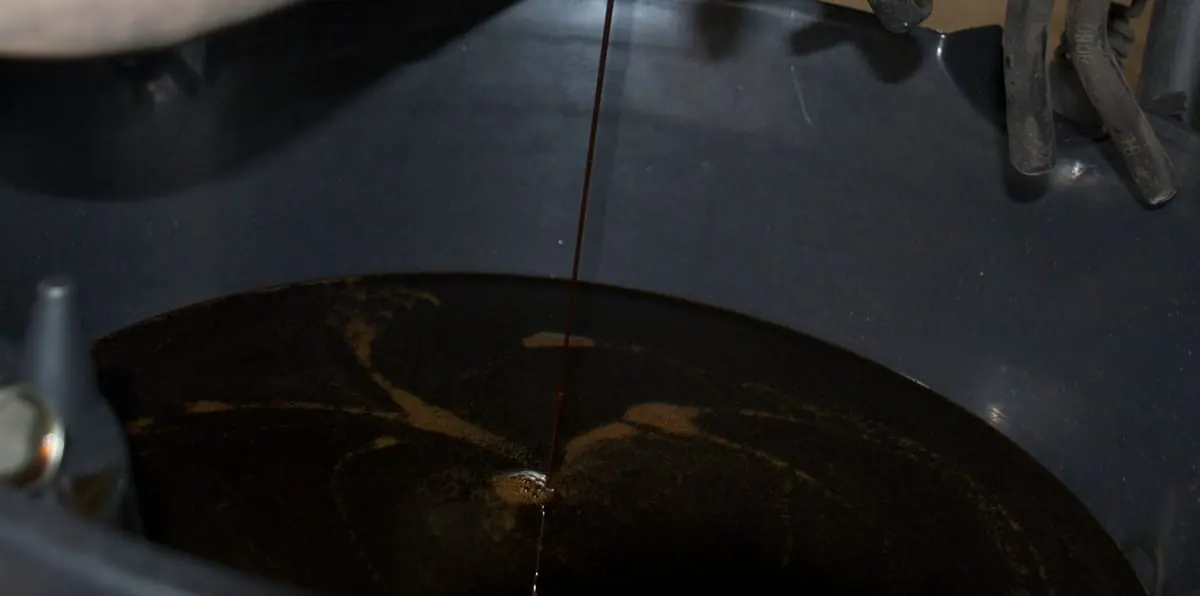 Used motor oil draining into a catch pan